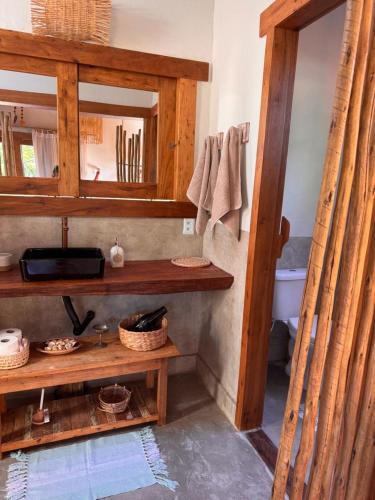 a bathroom with a wooden shelf and a mirror at Casa Kaûma in Corumbau
