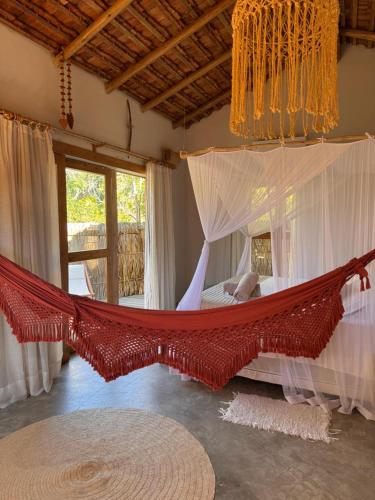 a hammock in a room with a bedroom at Casa Kaûma in Corumbau