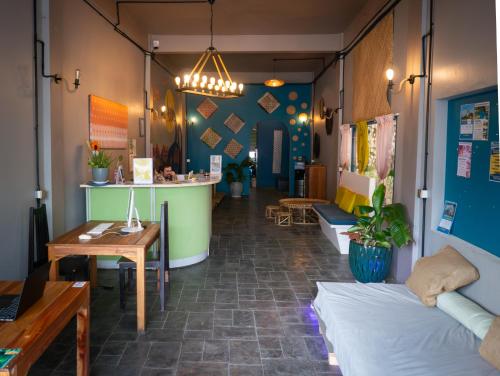 a room with a bar and a table and chairs at TT Premium Hostel Vientiane in Vientiane