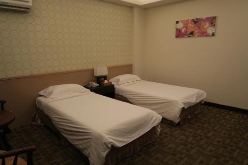 a room with two beds in a hotel room at Moon Villa in Zhongpu