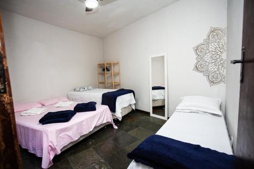a room with three beds in a room at Espaço Sideral - Quartos com ar-condicionado, 5min Estádio Maracanã, 8min UERJ, shopping, 12min metrô, wi-fi 300mbp, ampla área comum com cozinha - prático e confortável in Rio de Janeiro
