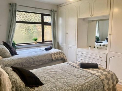 a bedroom with two beds and a large window at Leixlip 4-Bed Home Sleeps 6 Ideal for Groups in Kildare