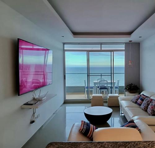 a living room with a couch and a tv at Departamento Diamond Beach Tonsupa in Tonsupa