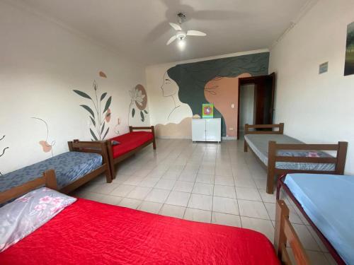 a room with two beds and a painting on the wall at Hostel Casarão SV in São Vicente