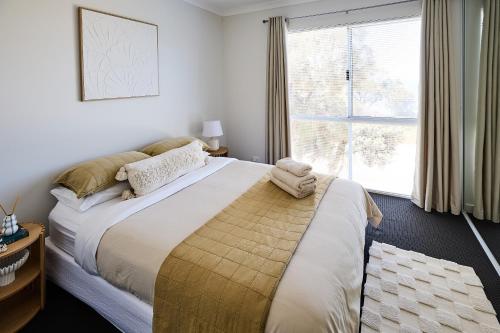 a bedroom with a large bed and a window at Water's Edge 4x4 Townhouse in Falcon