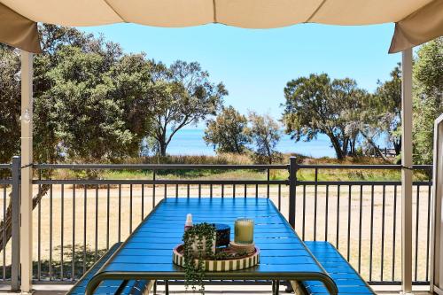 a blue table on a balcony with a view of the ocean at Water's Edge 4x4 Townhouse in Falcon