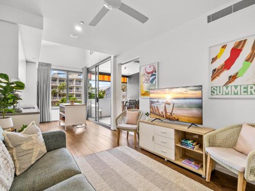a living room with a couch and a tv at Executive Beachside Getaways in Maroochydore