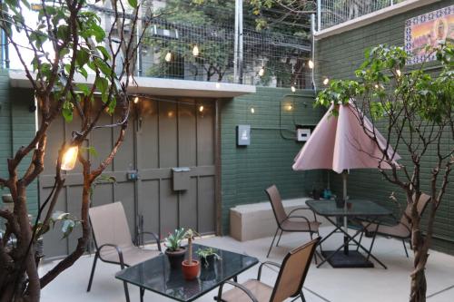 a patio with tables and chairs and an umbrella at Casa Saratoga in Mexico City