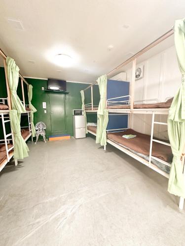 a room with several bunk beds in it at ゲストハウスまるとく in Yoron