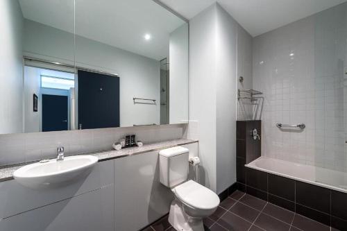 a bathroom with a sink and a toilet and a mirror at Mantra 100 Exhibition in Melbourne