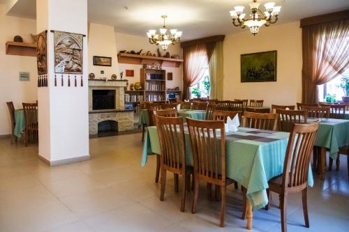 Un comedor con mesas y sillas y una chimenea. en Asia Hotel, en Bishkek