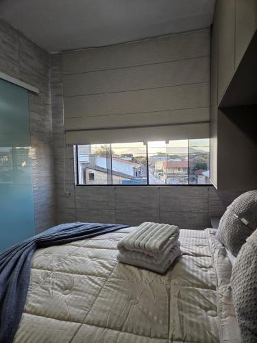 a bedroom with a large bed with a large window at Brisa Do Mar in Saquarema