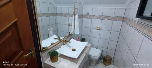 a bathroom with a sink and a toilet at Sobrado 4 quartos com piscina praia do tabuleiro in Barra Velha