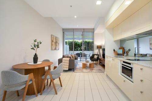 a kitchen and living room with a table and chairs at The Alta Apartments by Urban Rest in Sydney