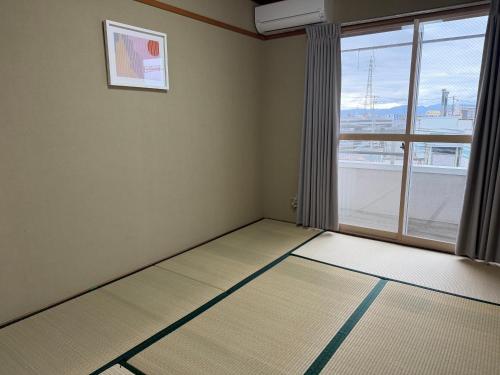 an empty room with a large window with a view at Cozy Family Room in Matsumoto203 in Matsumoto