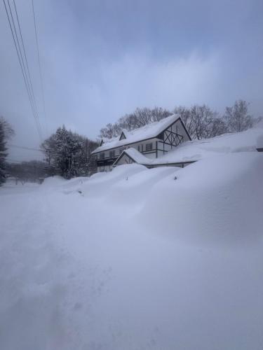 a house covered in snow in front at ALBERGO DEL PESCATORE in Minamiaizu