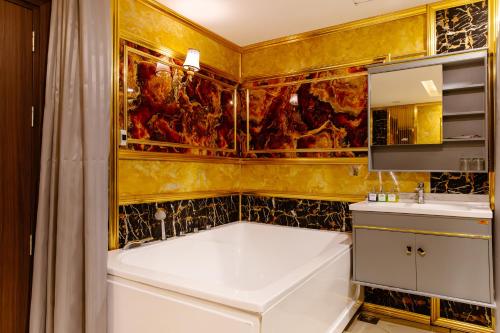 a bathroom with a large tub and a sink at Boss Palace Hotel in Ho Chi Minh City