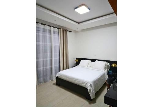 a hotel room with a bed and a window at Aviya - Studio meublé avec chambre et Séjour in Dakar