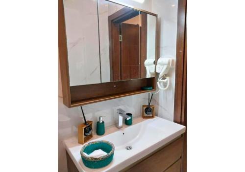 a bathroom with a sink and a mirror at Aviya - Studio meublé avec chambre et Séjour in Dakar