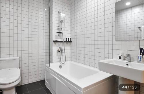 a bathroom with a tub and a toilet and a sink at Just Sleep Hotel Jihaeng Station in Tongduch'ŏn