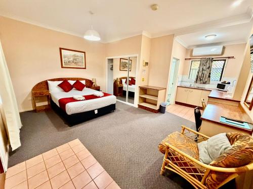 a bedroom with a bed and a living room at Townview Motel in Mount Isa