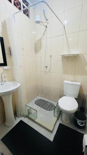 a bathroom with a shower and a toilet and a sink at Kitnet com ar-condicionado e entrada privativa SC in Itajaí
