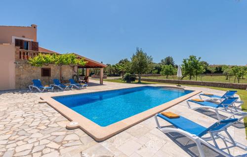 a swimming pool with chairs and a house at Can Cremat in Artá