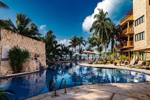 a swimming pool at a resort with palm trees at Esplendor by Wyndham Isla Mujeres All Inclusive in Isla Mujeres