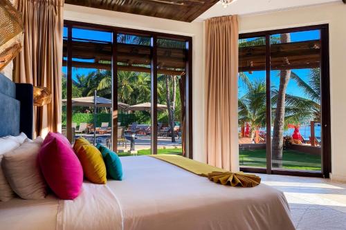 a bedroom with a large bed with colorful pillows at Esplendor by Wyndham Isla Mujeres Boutique All Inclusive in Isla Mujeres