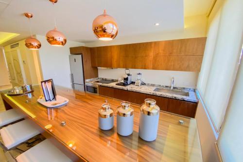 a kitchen with a wooden counter top with three silver containers at Esplendor by Wyndham Isla Mujeres Boutique All Inclusive in Isla Mujeres