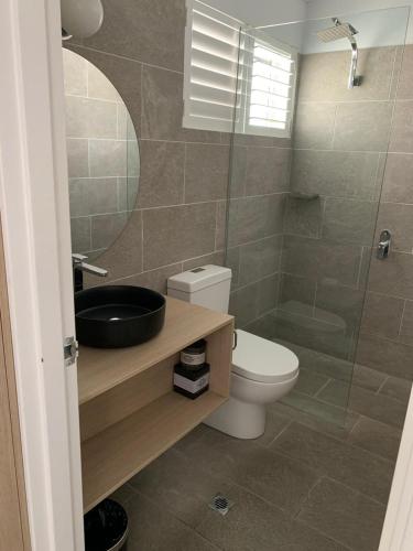 a bathroom with a toilet and a sink and a shower at Batemans Bay Lodge in Batemans Bay