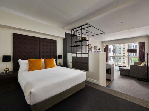 a bedroom with a large white bed with orange pillows at Mantra 2 Bond Street in Sydney
