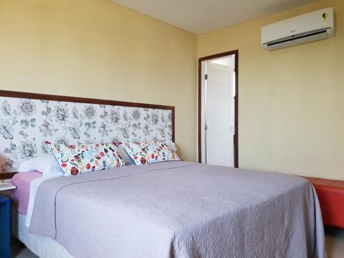 a bedroom with a large bed with red and white pillows at Hotel blue Ocean 3 in Parnamirim