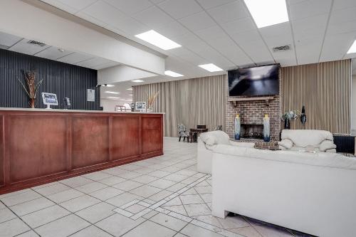 a lobby with a waiting room with a tv on a wall at Cottonwood Suites Savannah Hotel & Conference Center in Pooler