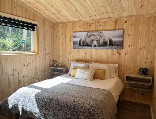 a bedroom with a bed with a picture of a bear at Refuge du Kodiak BORD DE L EAU in Sainte-Germaine-du-Lac-Etchemin