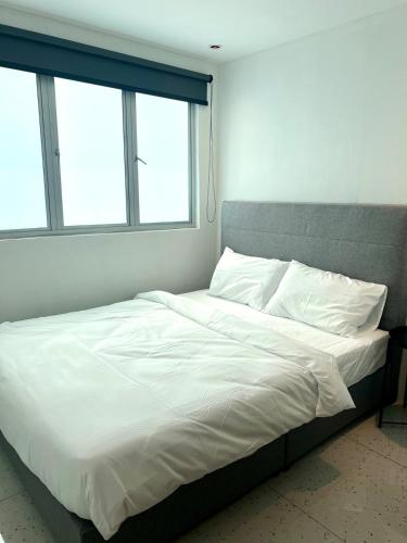 a bed with white sheets and pillows in a bedroom at Casa for 8 ipoh Central Pet Allowed in Ipoh