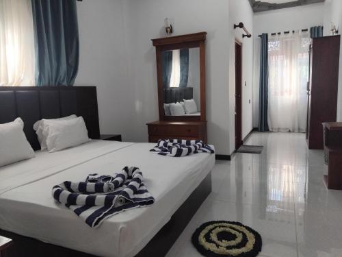 a bedroom with two beds and a mirror at SAS Villa in Ahungalla