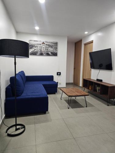 a living room with a blue couch and a tv at NSI Alameda Park Humboldt Mexico City in Mexico City