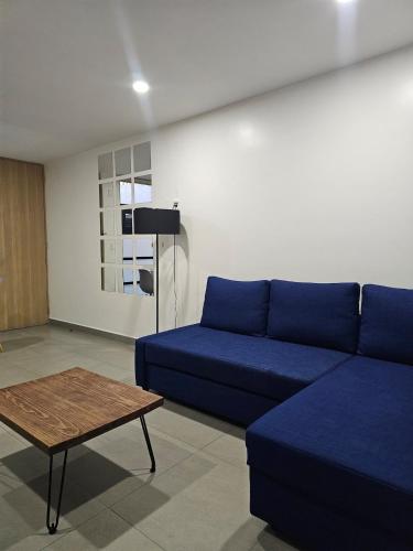 a living room with a blue couch and a table at NSI Alameda Park Humboldt Mexico City in Mexico City