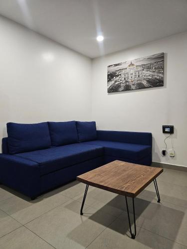 a blue couch in a living room with a table at NSI Alameda Park Humboldt Mexico City in Mexico City