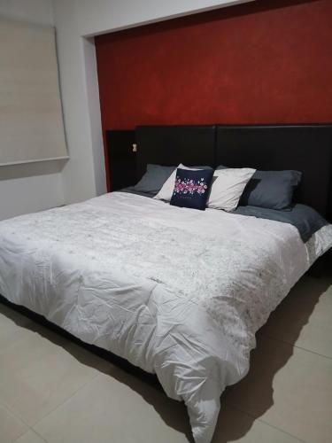 a large bed with white sheets and blue pillows at Elefante blanco in Boca del Río