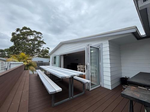 a deck with a picnic bench on a house at Watts @ Callala Beach-Pet Friendly in Callala Beach