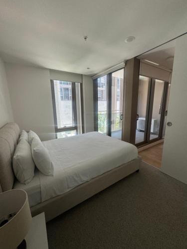 a bedroom with a large bed and a large window at Evermore Apartments in Melbourne
