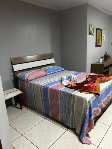 a bedroom with a large bed with colorful blankets at Drica Pousada in São Gabriel