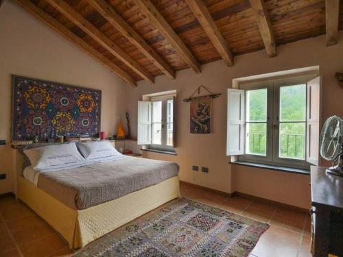 a bedroom with a bed and two windows and a rug at Casa Melabruna, 5 terre biker friendly in Pignone