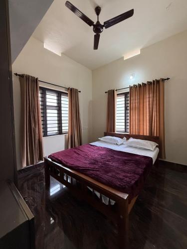 a bedroom with a large bed with a ceiling fan at AP'S Homestay Nilambur in Nilambūr