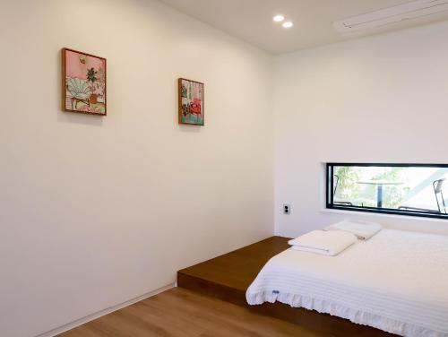 a white room with a bed and two pictures on the wall at Damonga in Damyang