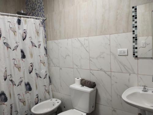 a bathroom with a toilet and a sink at M&M Cipolletti in Cipolletti