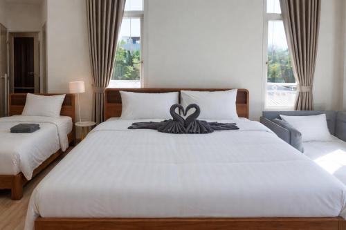 a bedroom with two beds with a bow on it at Areava Pool Villa Cha-am บ้านพักชะอำ พูลวิลล่า ติดชายหาดชะอำ in Cha Am