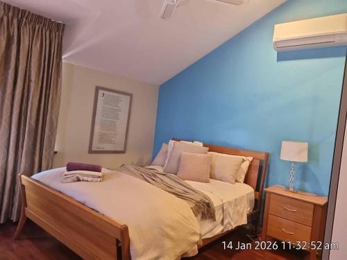 a bedroom with a bed with a blue wall at Angel Apartment in Perth